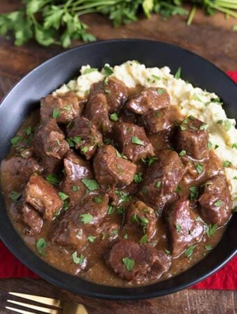 Beef Tips with mashed potatoes in a black bowl