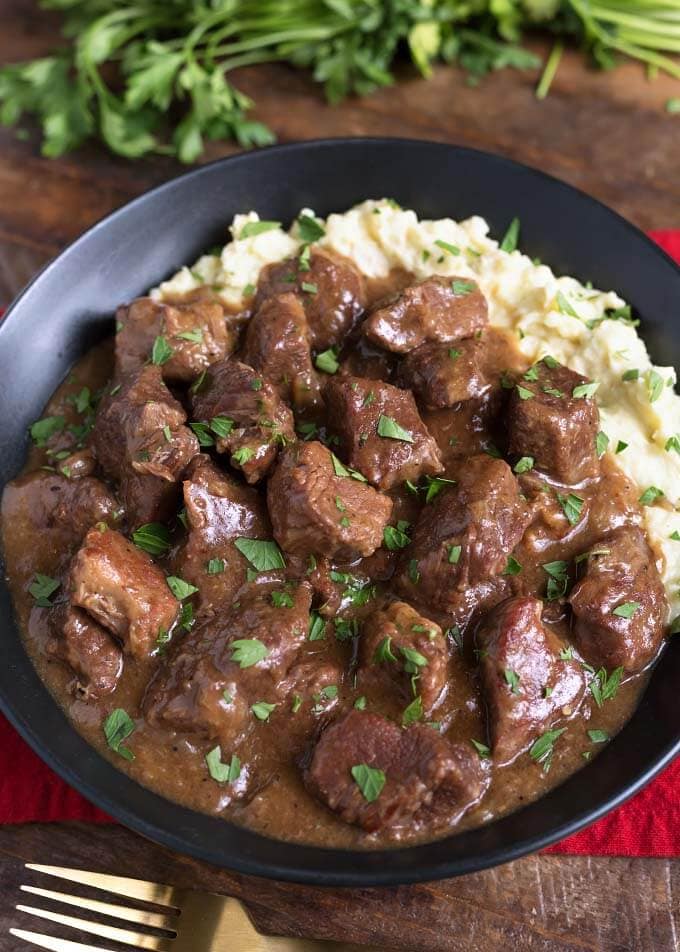 Beef Tips with mashed potatoes in a black bowl