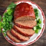 Easy Slow Cooker Meatloaf on a white plate garnished with parsley