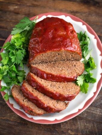 Easy Slow Cooker Meatloaf on a white plate garnished with parsley