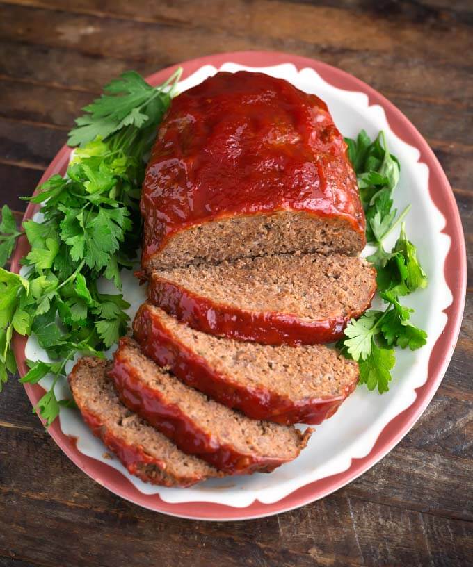 Easy Slow Cooker Meatloaf on a white plate garnished with parsley