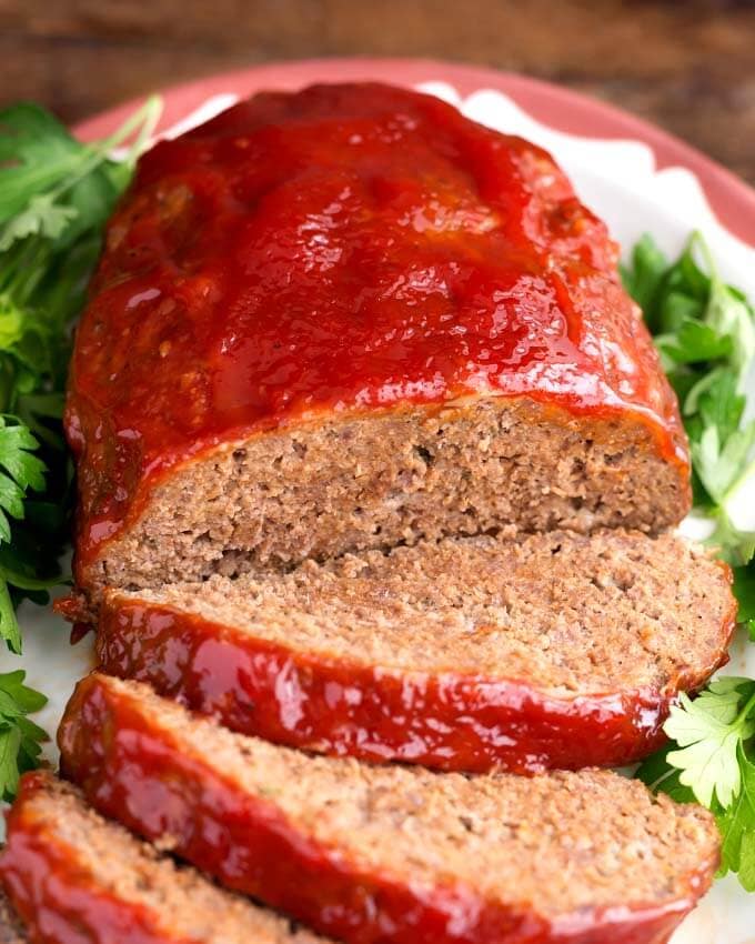 Sliced Meatloaf on white plate garnished with parsley