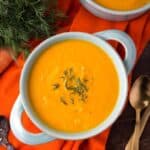 Pressure Cooker Carrot Soup in a light blue bowl on orange background