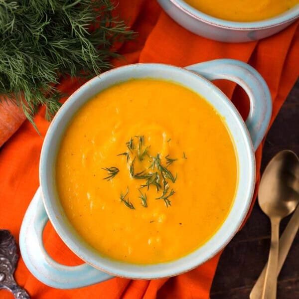 Pressure Cooker Carrot Soup in a light blue bowl on orange background
