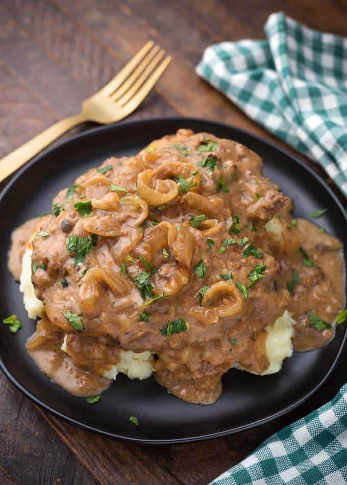 Pressure Cooker Cube Steak with Onion Gravy on black plate