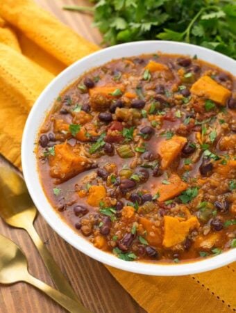 Pressure cooker Sweet Potato Quinoa Chicken Chili in a white bowl on yellow napkin