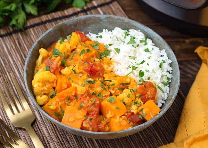 Pressure Cooker Vegetable Curry with rice in gray bowl next to gold fork
