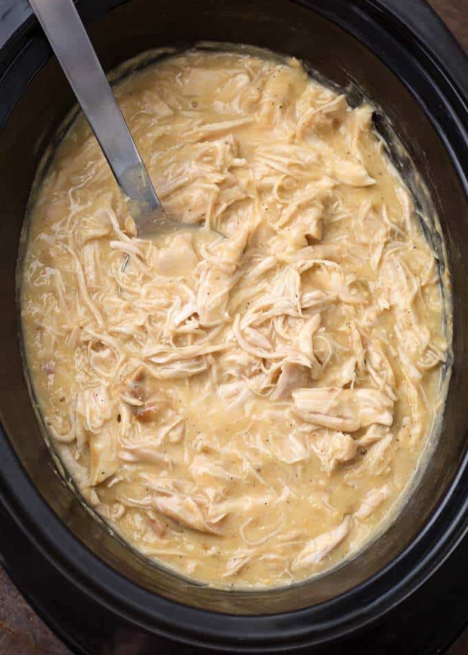 Chicken and Gravy in slow cooker with metal serving spoon