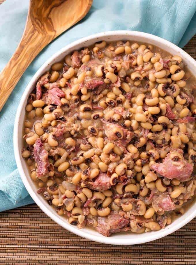 Southern Pressure Cooker Black Eyed Peas in white bowl next to wooden spoon