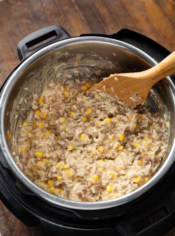 Cheesy Hamburger Rice Casserole in pressure cooker pot with wooden spoon