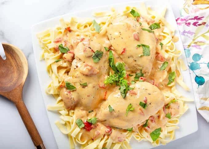 pressure cooker Cajun Chicken Breasts on square plate next to wooden spoon