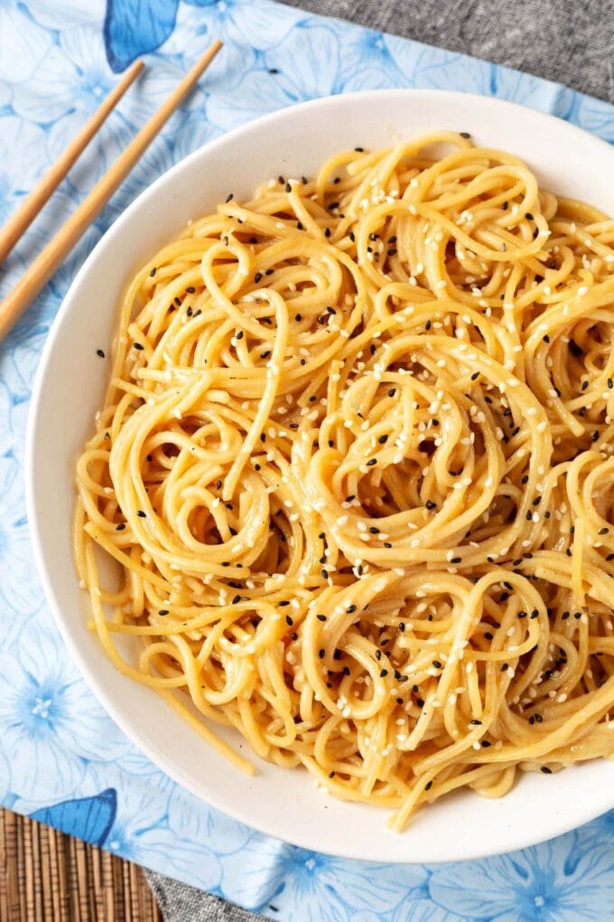 Garlic Noodles in white bowl next to wooden chopsticks