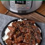 Instant Pot Mongolian Beef on black dish in front of IP