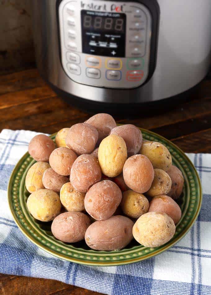 Syracuse Salt Potatoes on a green plate in front of a pressure cooker