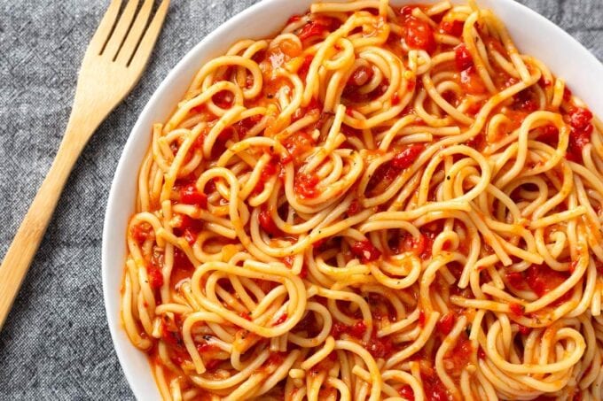 Instant Pot Roasted Red Pepper Pasta on white plate next to wooden fork