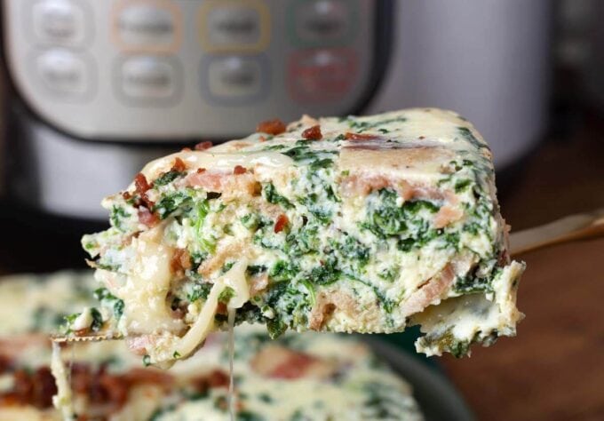 Slice of Pressure Cooker Spinach Bacon Crustless Quiche on serving utensil