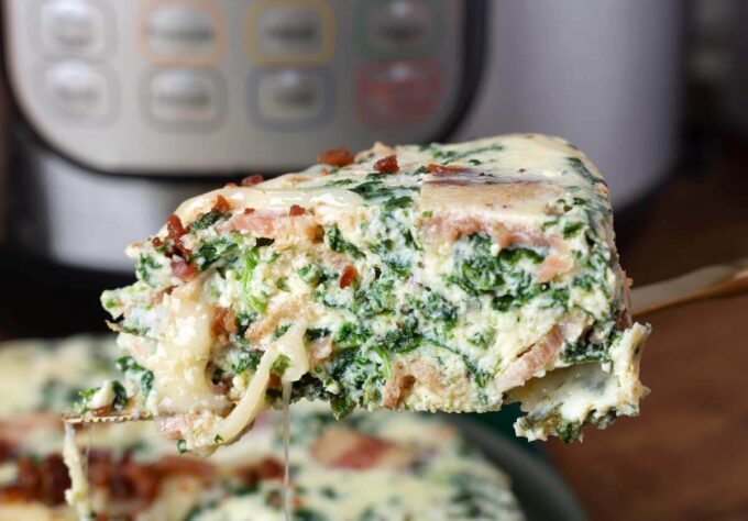 Slice of Pressure Cooker Spinach Bacon Crustless Quiche on serving utensil