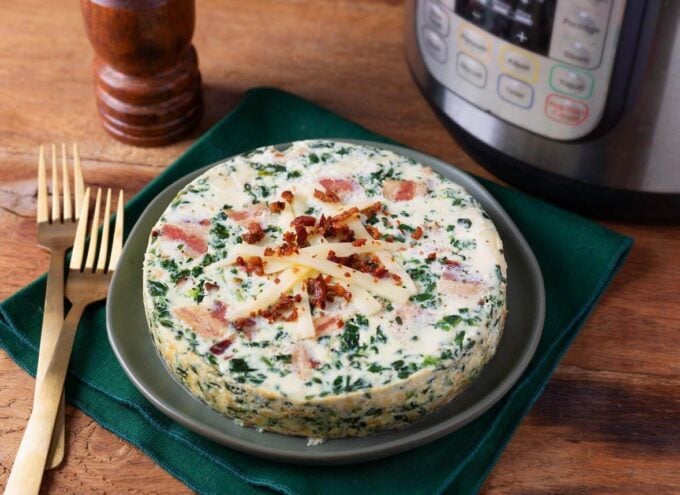 whole pressure cooker Spinach Bacon Crustless Quiche on a plate next to two forks