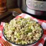 Instant Pot Dirty Rice in a white bowl in front of the pot