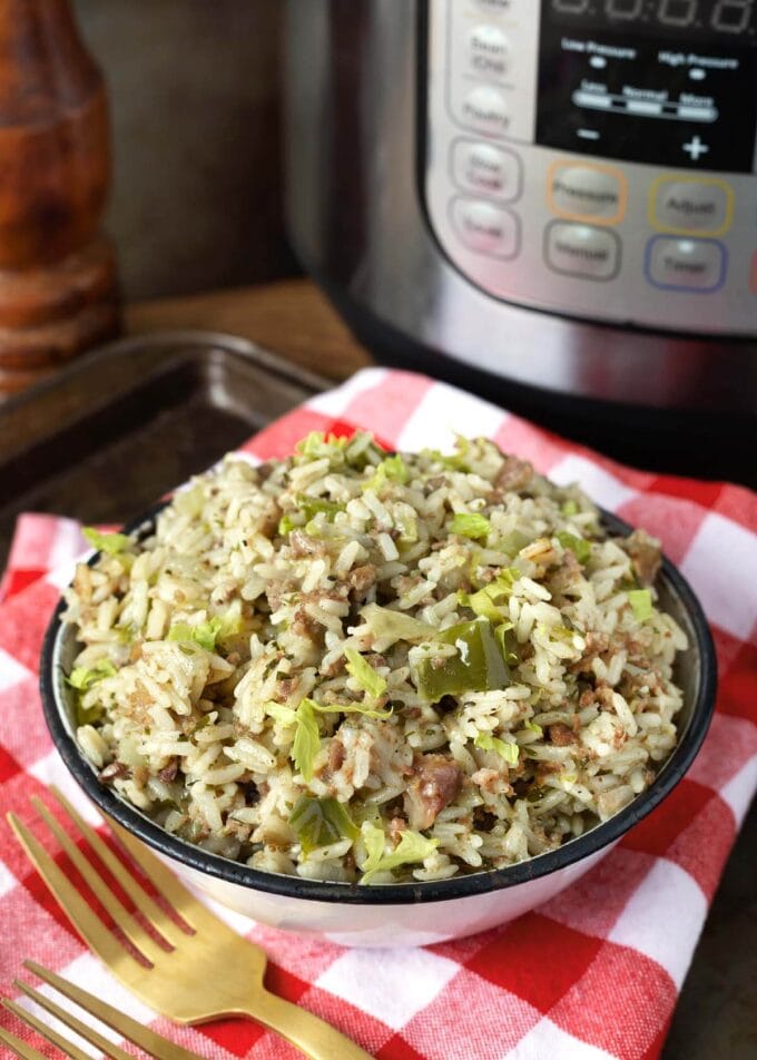 Instant Pot Dirty Rice in a white bowl in front of the pot