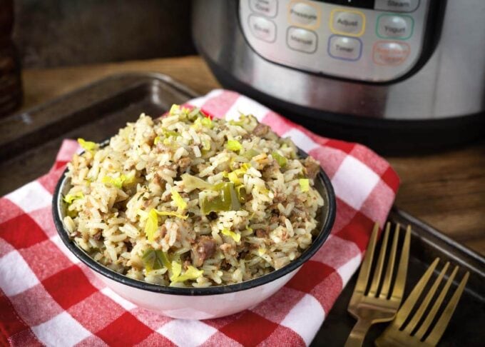 Instant Pot Dirty Rice in a white bowl in front of the pot