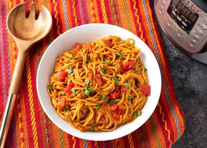 Instant Pot Taco Spaghetti in a white bowl on a red orange striped cloth