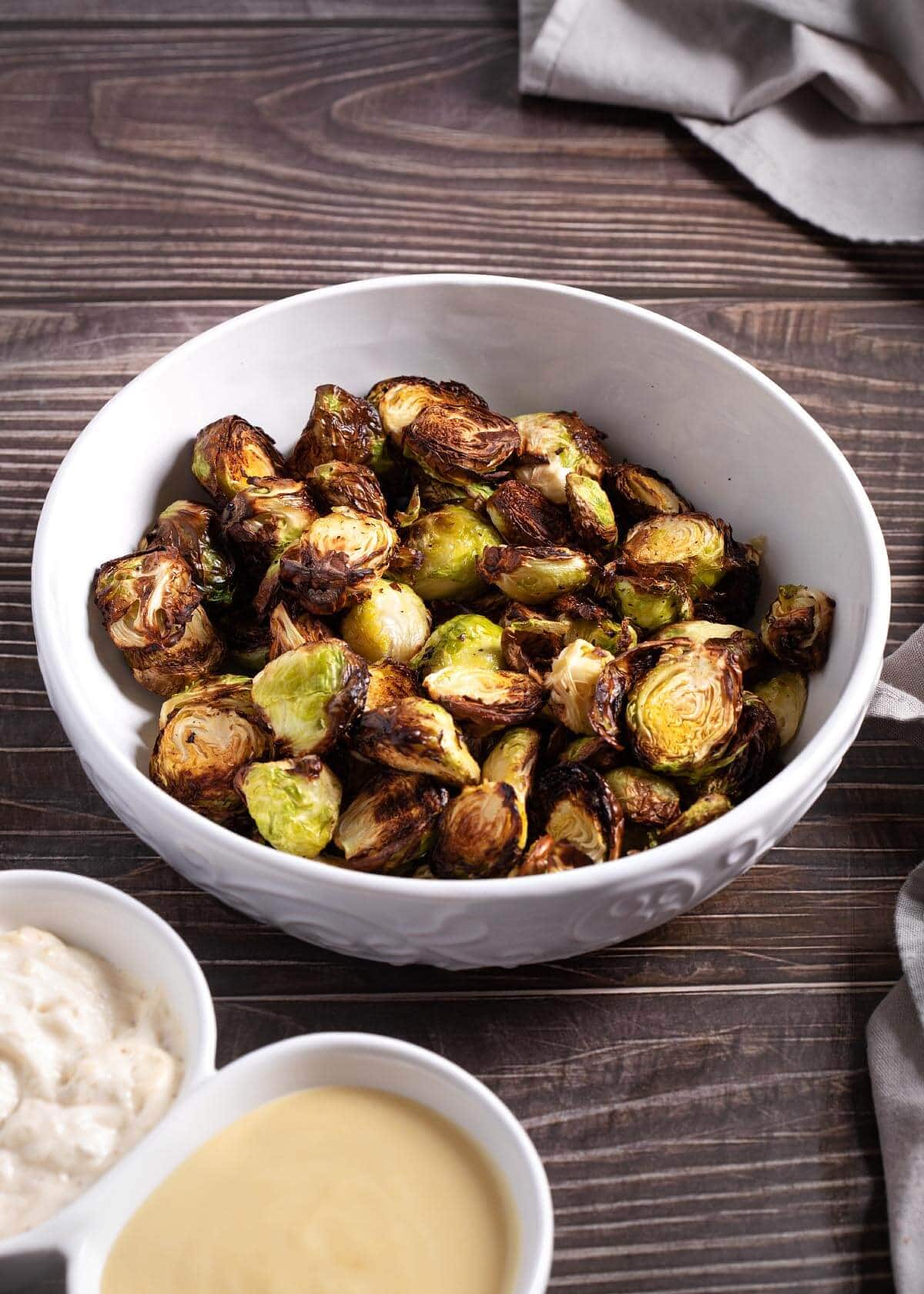 Air Fryer Brussels Sprouts in a white bowl, wood background