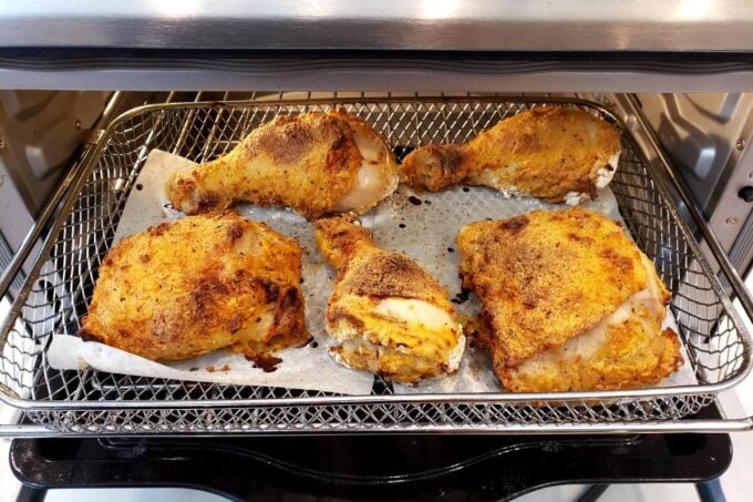 air fried chicken pieces in air fryer ready to be flipped over