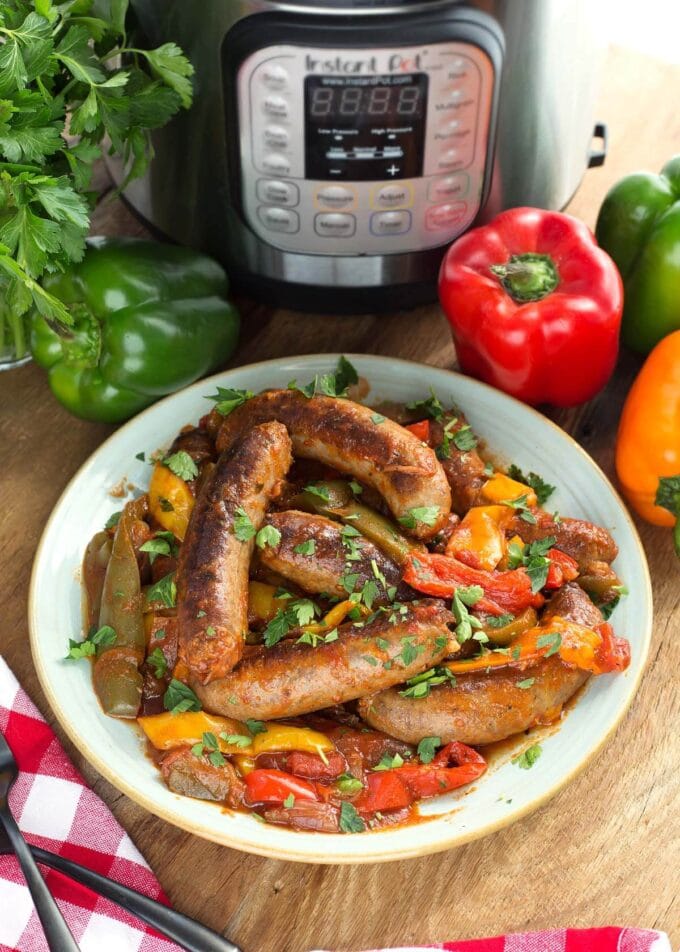 Instant Pot Sausage and Peppers on a white plate with the IP in background