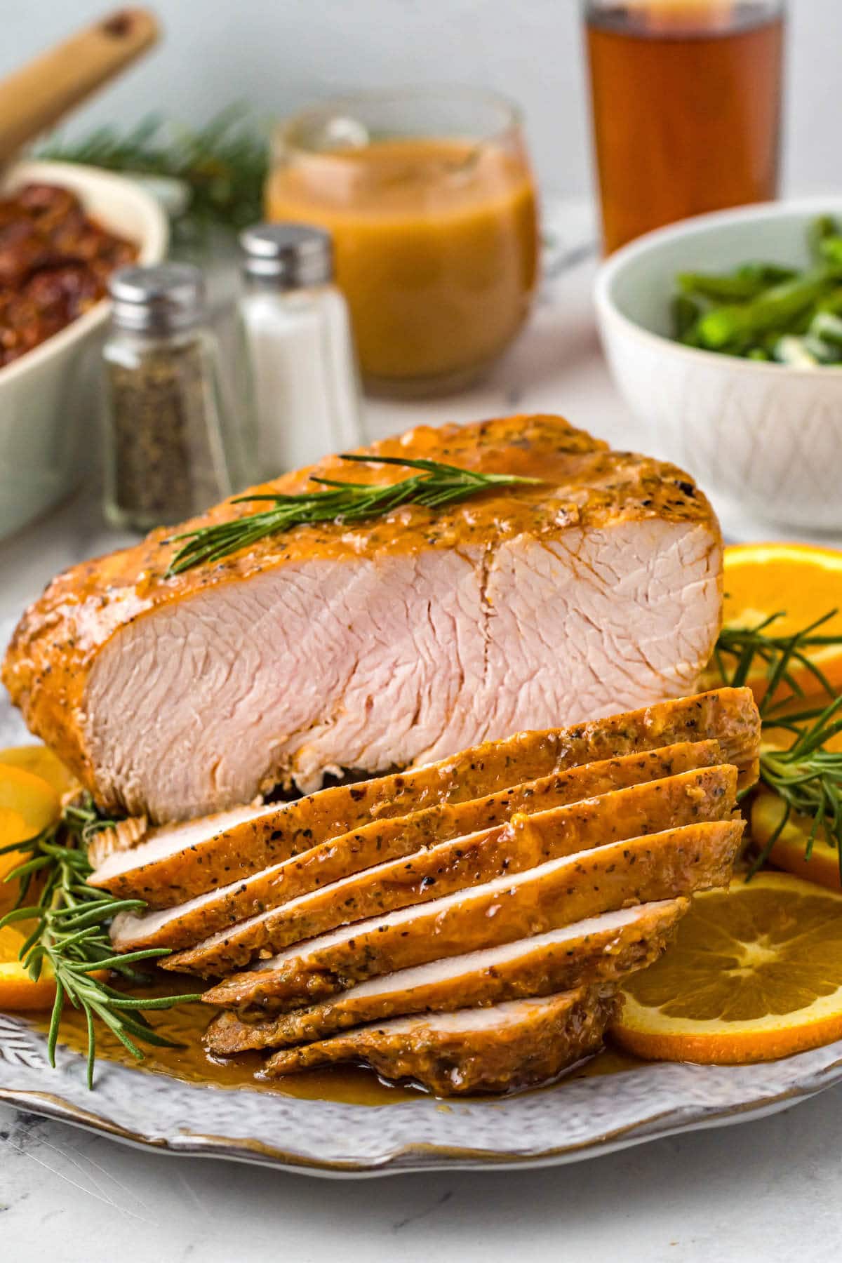 air fryer turkey breast on a plate sliced with garnishes