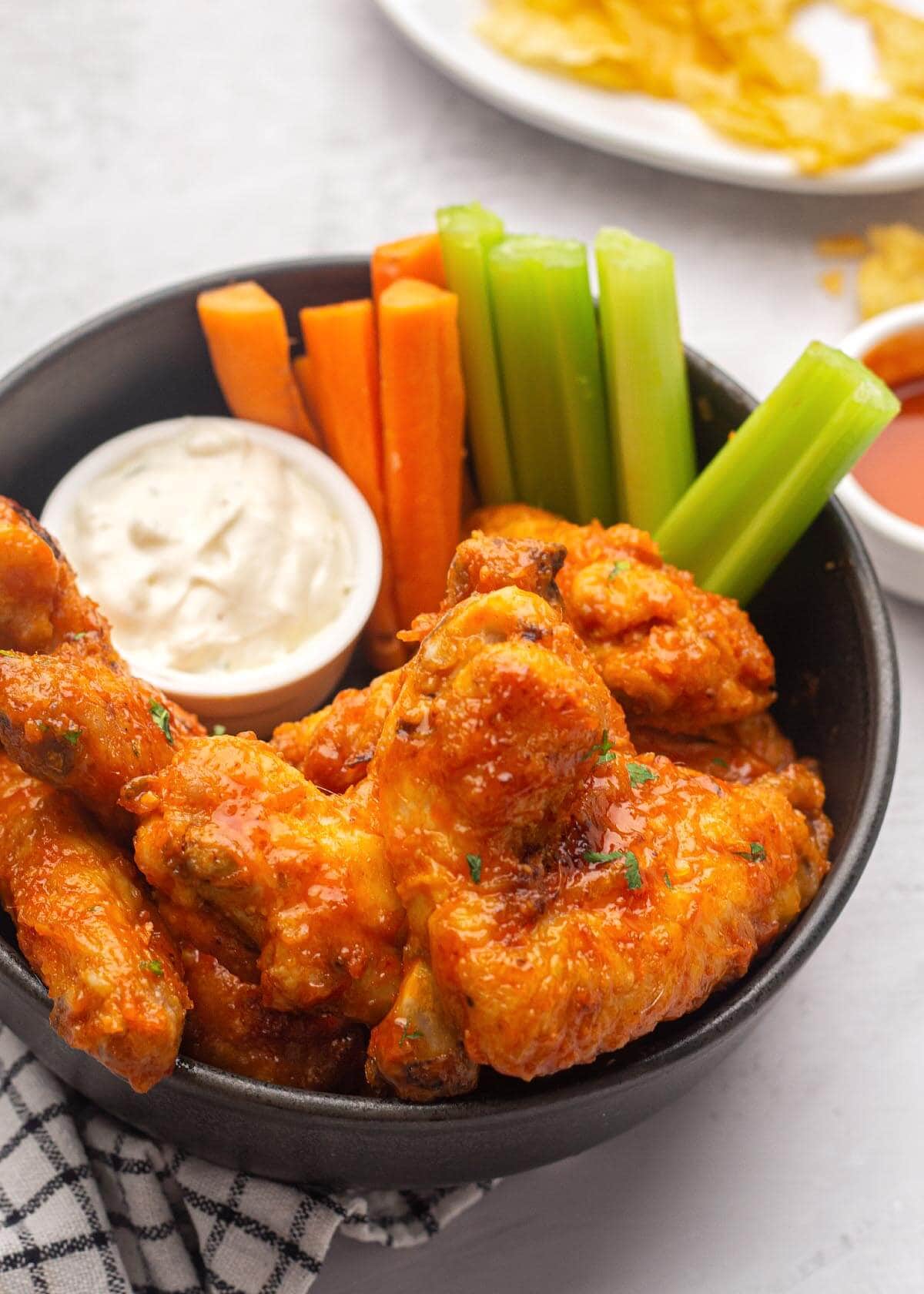 Air Fryer Buffalo Chicken Wings in a bowl with carrots and celery