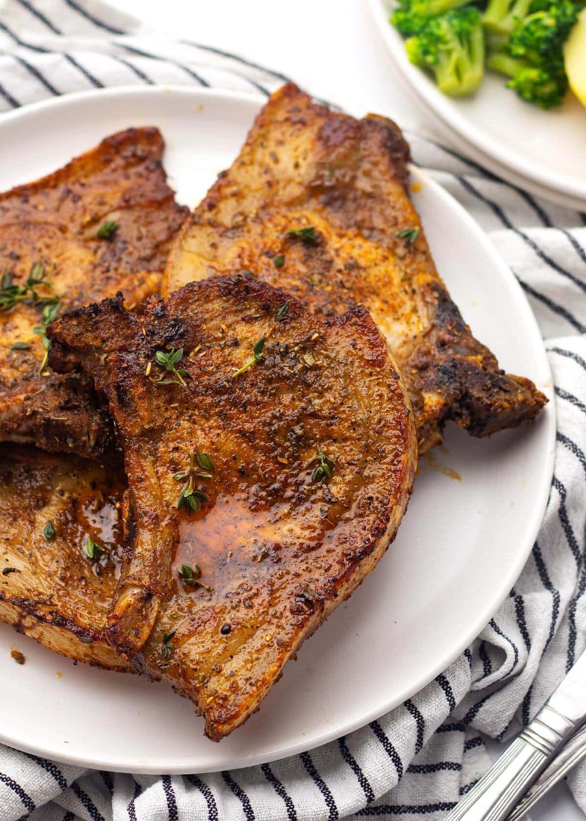 4 air fryer pork chops on a white plate