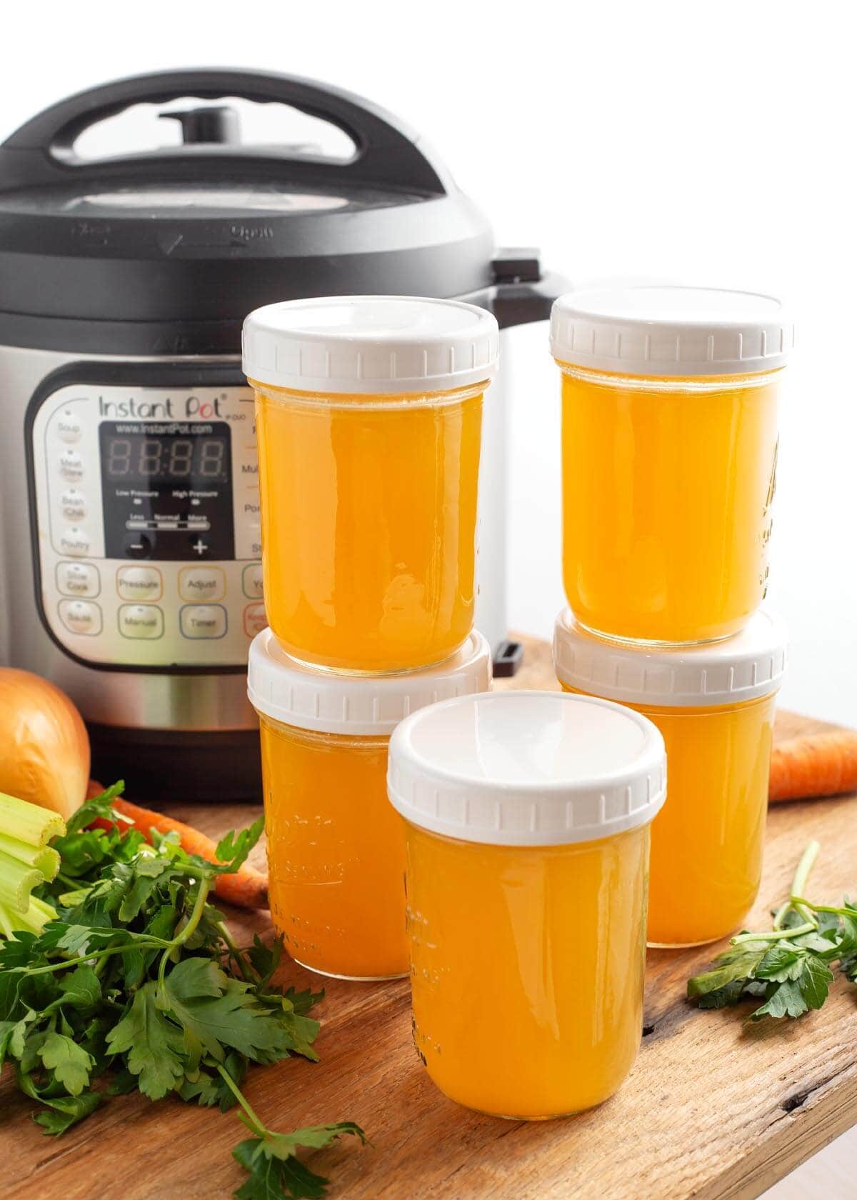 Instant Pot Chicken Broth in jars in front of IP