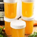 Instant Pot Chicken Broth in 4 jars in front of the IP