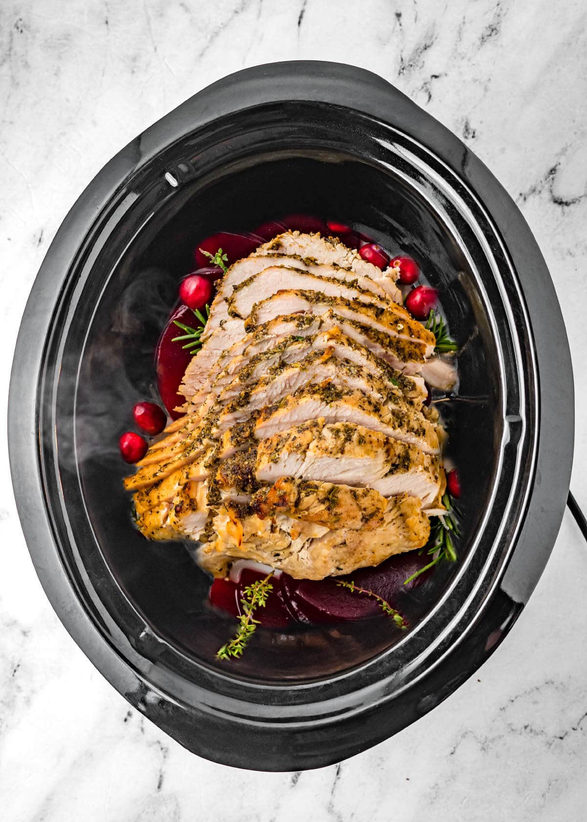 Slow Cooker Turkey Breast in a black crock with cranberries