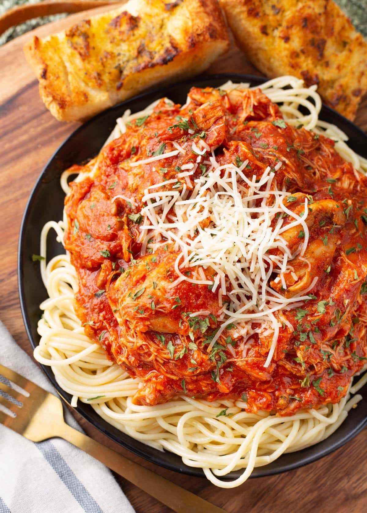 Slow Cooker Chicken Cacciatore on a black plate with noodles