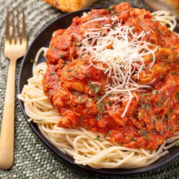 Chicken Cacciatore on a black plate on noodles