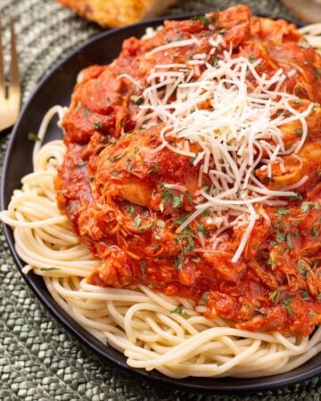 Chicken Cacciatore on a black plate on noodles