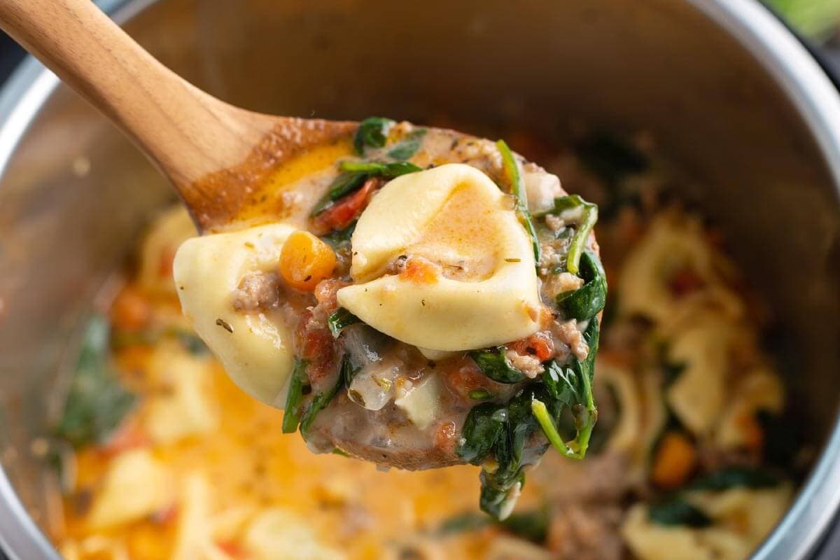 Creamy Tortellini Soup in a wood ladle