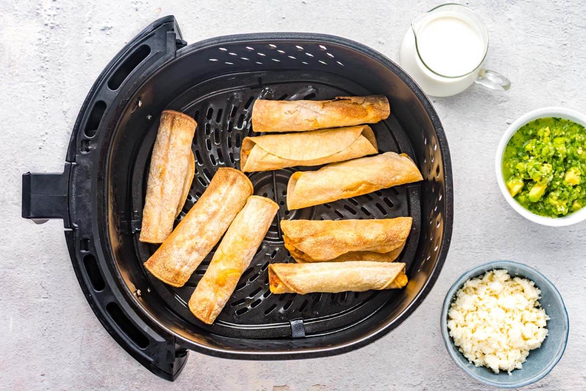 chicken taquitos in an air fryer basket