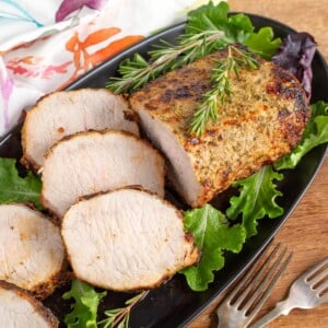 air fryer pork roast on black plate with slices