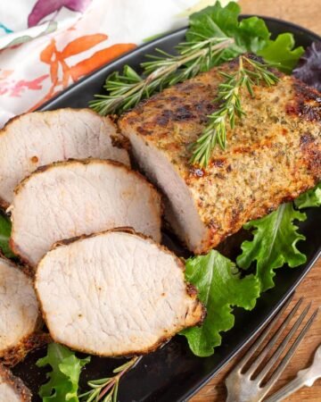 air fryer pork roast on black plate with slices