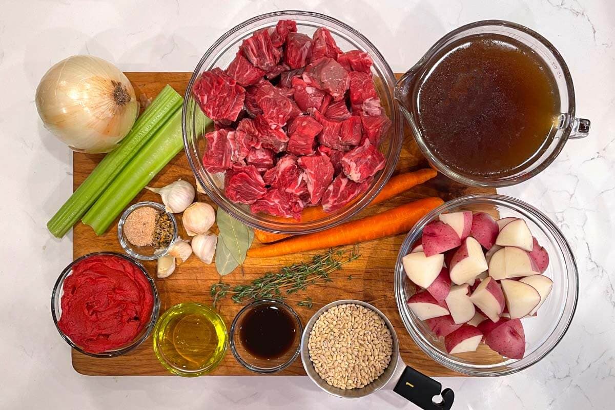 photo of ingredients for Instant Pot Beef Barley Stew on a cutting board.