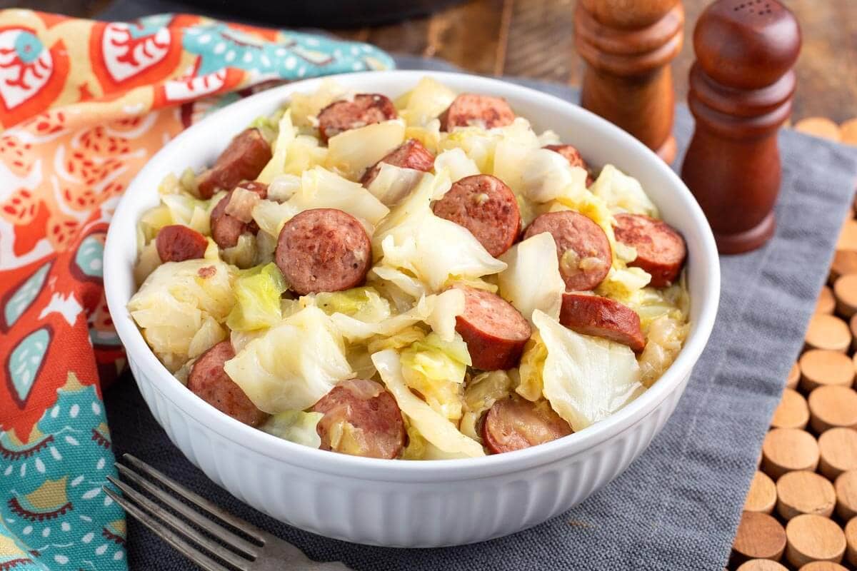 Cabbage and Kielbasa in a white bowl.
