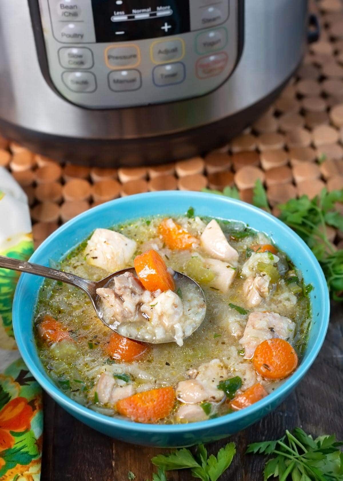 Instant Pot Chicken Rice Soup in a blue bowl in front of IP.