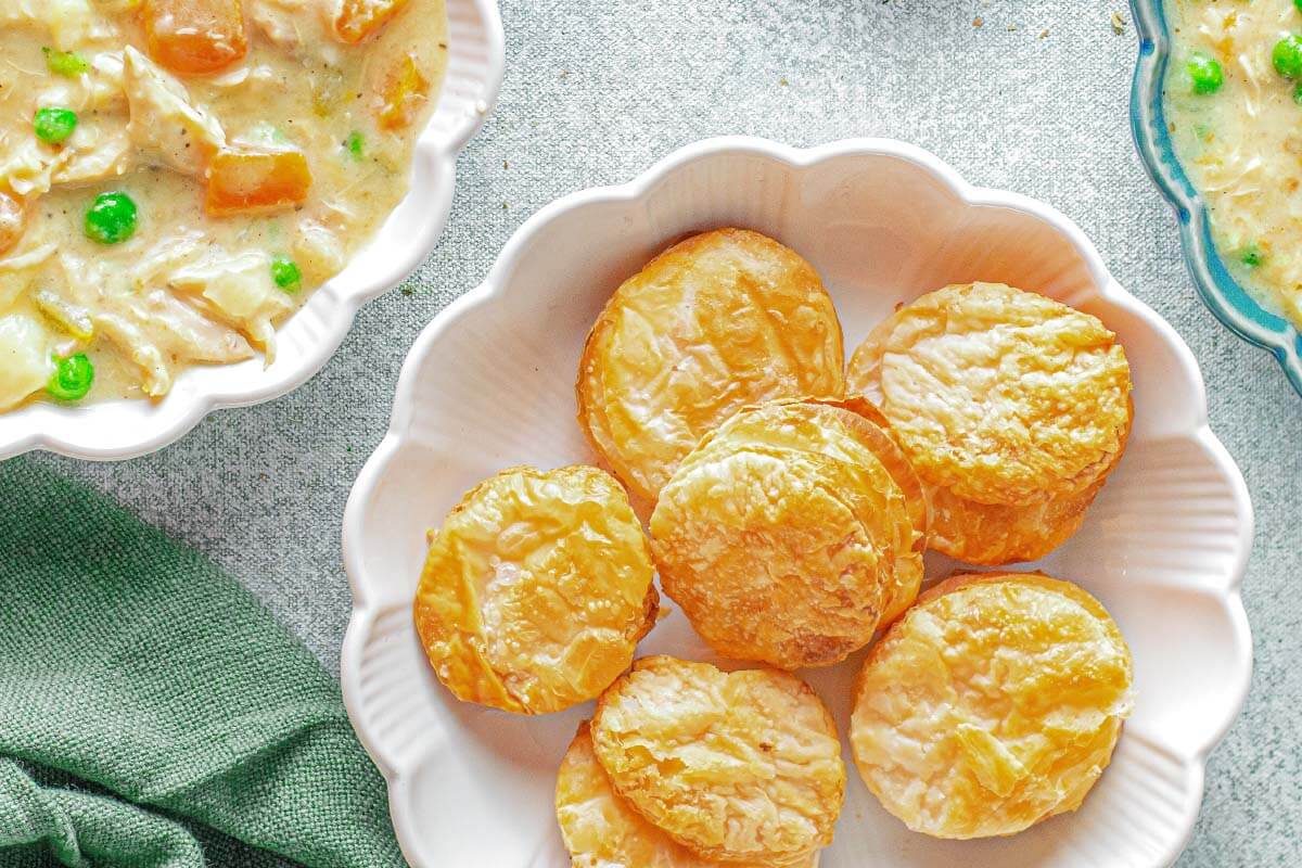 biscuits in white bowl with soup bowls partially shown.