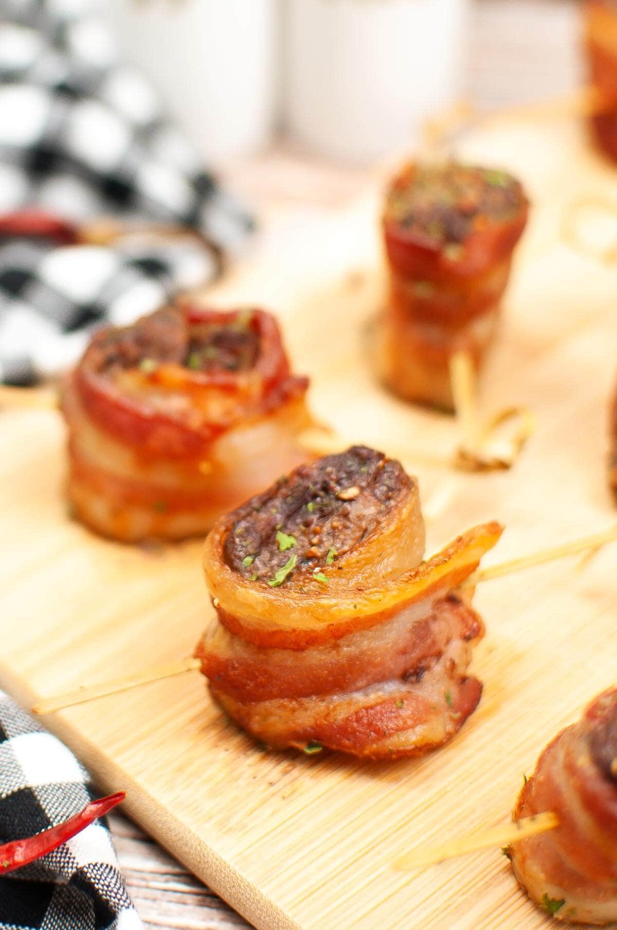 Air Fryer Bacon Wrapped Steak Bites on a wood board.