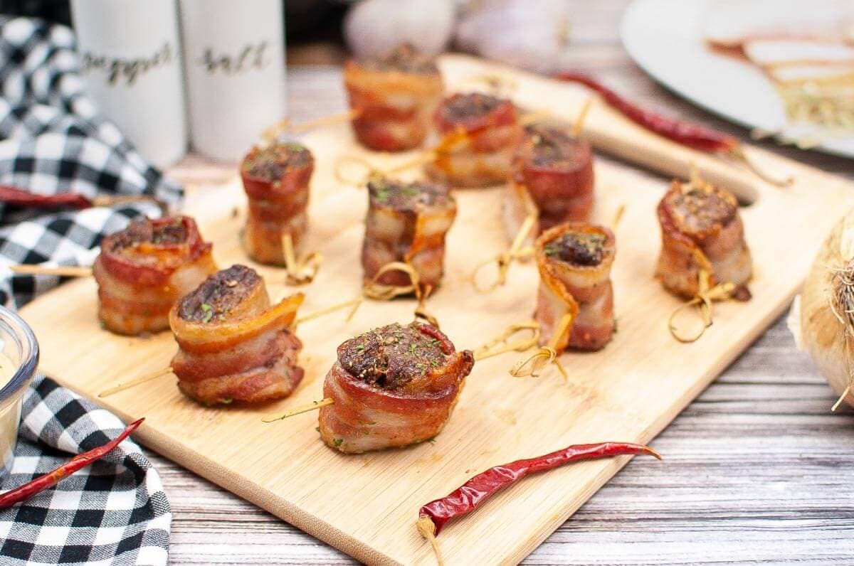 several steak bites on a wood board.