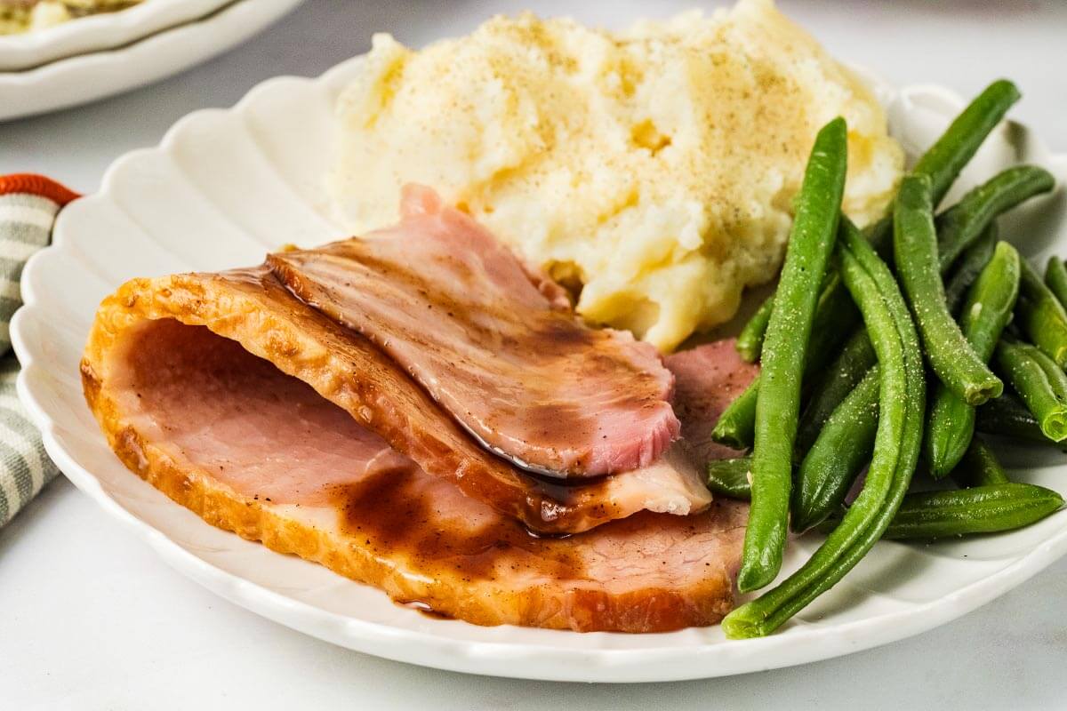 plate of Slow Cooker Ham, green beans, and mashed potatoes on a white plate