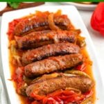 sausage and peppers on a white platter.